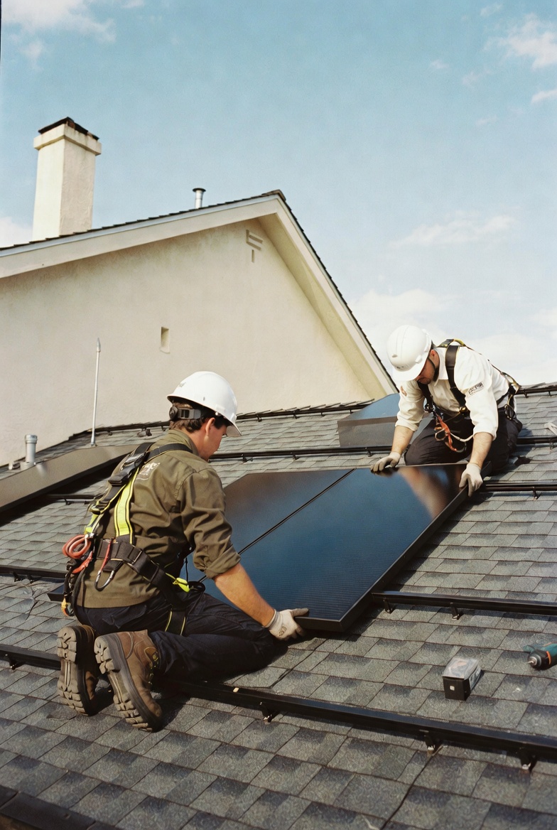 Solar installers mounting panels on a residential roof